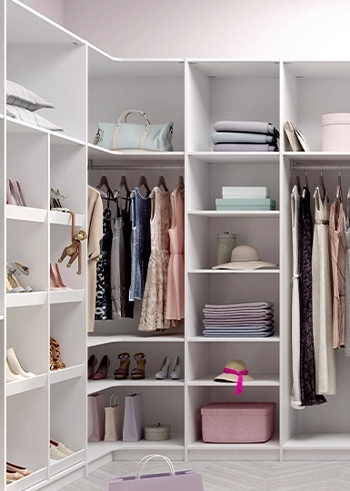 Heller begehbarer Kleiderschrank mit Regalen und Schränken in einem Ankleidezimmer.