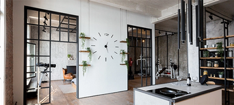 Türen im Loft-Stil mit schwarzen Metallrahmenelementen verbinden Küche und Wohnbereich.
