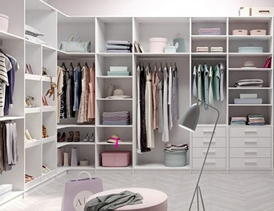 Heller begehbarer Kleiderschrank mit Regalen und Schränken in einem Ankleidezimmer