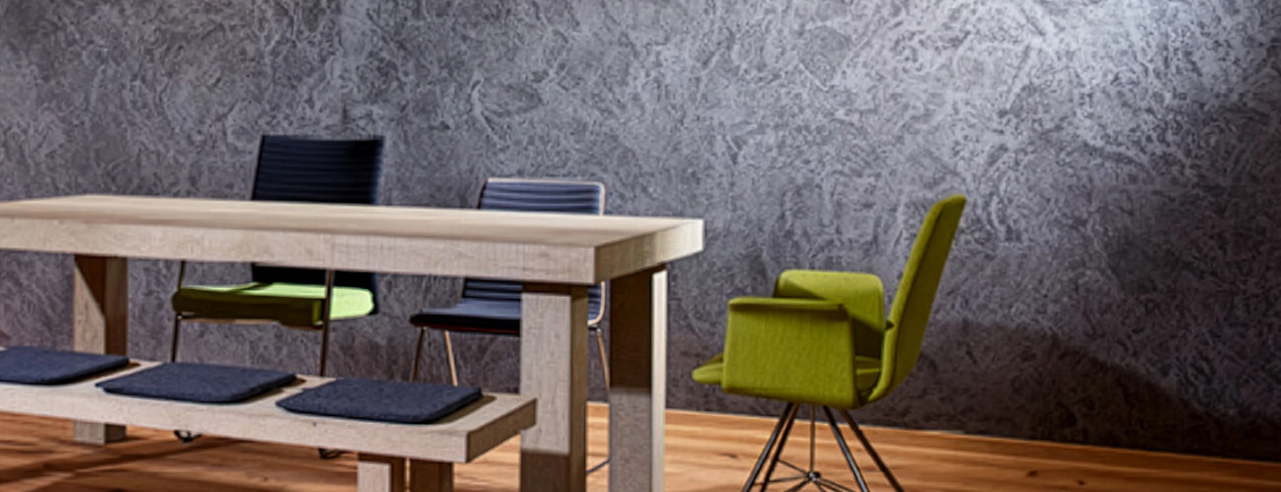 Essbereich mit Holztisch, Kaminofen und dekorativer Wandgestaltung aus Steinputz.