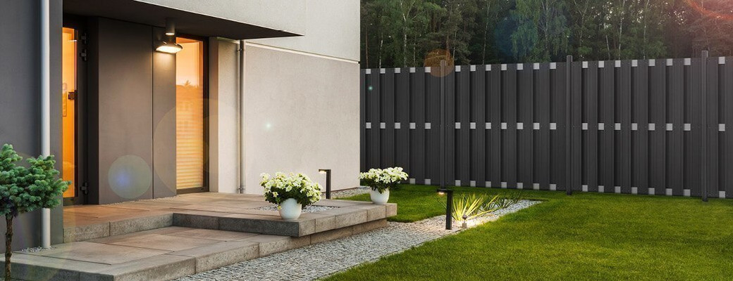 Grauer WPC-Zaun in der Nähe eines Hauses