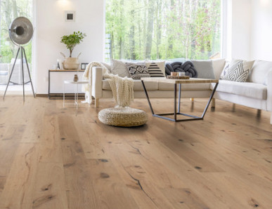 Im Wohnzimmer wurde Parkett in Langdielen-Optik verlegt. Ein Sofa und einige liebevoll platzierte Dekoelemente runden das gemütliche Ambiente ab.