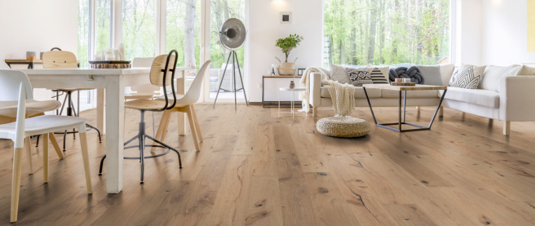 Im Wohnzimmer wurde Parkett in Langdielen-Optik verlegt. Ein Sofa und einige liebevoll platzierte Dekoelemente runden das gemütliche Ambiente ab.