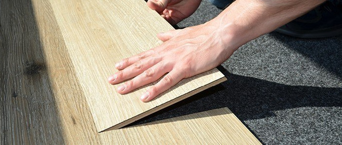 Handwerker verlegt Laminatboden – präzise Anpassung und professionelle Bodenmontage.