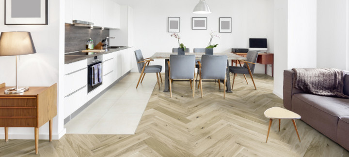 Wohn- und Essbereich mit hellem Fischgrätenparkett ausgelegt.