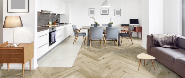 Wohn- und Essbereich mit hellem Fischgrätenparkett ausgelegt.