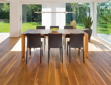 Die Küche ist mit massivem Boden ausgelegt. In der Mitte steht ein massiver Tisch mit Stühlen, und durch die Glasfenster sieht man den Ausgang zur Terrasse und zum Garten.