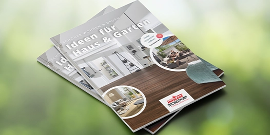 Ein Produktkatalog liegt vor einem Hintergrund aus grünen Blättern.