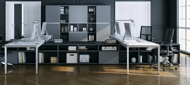 Graue Büromöbel und weiße Tische mit Arbeitsplätzen in einem Büro