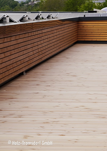 Große Dachterrasse mit hellen, naturgeölten Holzdielen und horizontaler Holzverkleidung für den Außenbereich.