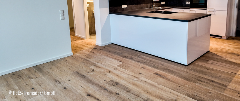 Offene Küche mit weißer Insel und warmem Eichen-Design Vinylboden.