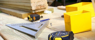 Werkzeuge und Holzbretter auf einer Baustelle – Präzision und Handwerkskunst bei der Holzmontage.