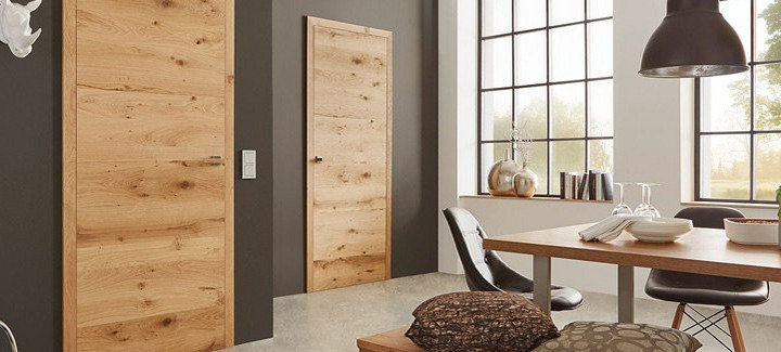 Innentüren mit markanter Holzmaserung an einer dunkelbraunen Wand in einer Wohnumgebung