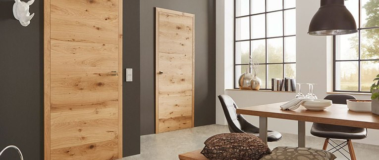 Innentüren mit markanter Holzmaserung an einer dunkelbraunen Wand in einer Wohnumgebung