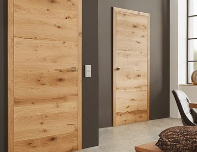 Innentüren mit markanter Holzmaserung an einer dunkelbraunen Wand in einer Wohnumgebung